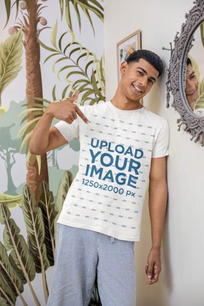 Mockup of a Happy Man Pointing at His T-Shirt in a Cozy Room