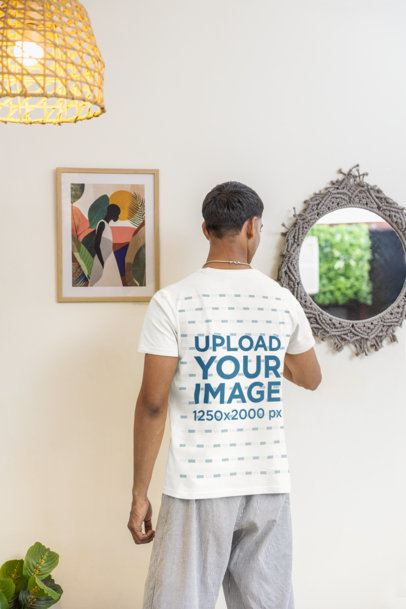 Round-Neck T-Shirt Mockup Featuring a Man Posing Backwards in a Cozy Room