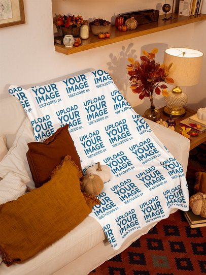 Mockup Featuring a Blanket Placed on a Sofa in a Living Room With Fall Decor