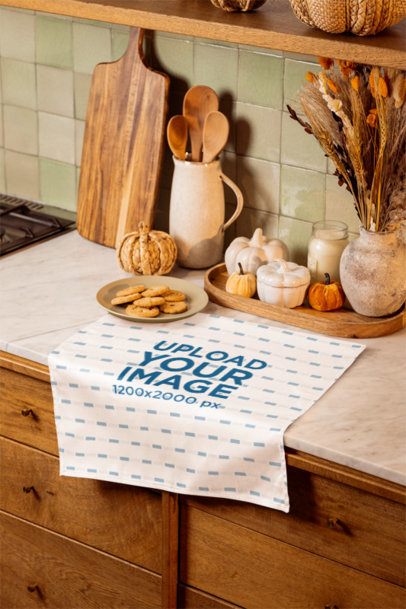 Mockup of a Kitchen Towel Placed on a Counter With a Cookies and Fall Decor