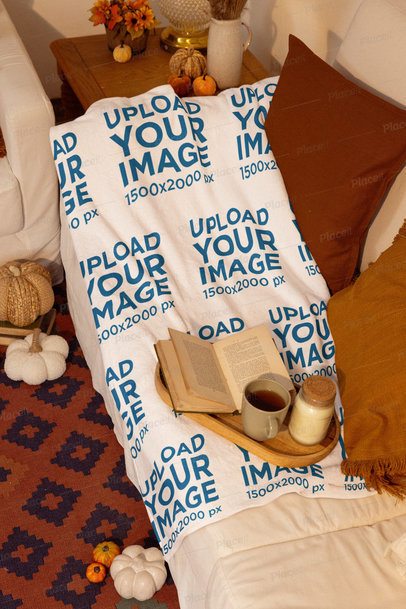 Fall-Inspired Mockup Featuring a Blanket Lying on a Couch With a Book and a Mug