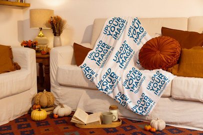 Mockup of a Sublimated Blanket Lying on a Cozy Couch With an Autumn Aesthetic