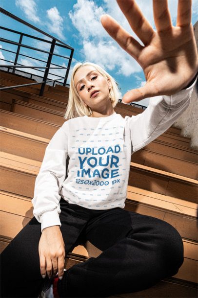 Comfort Colors Sweatshirt 1566 Mockup Featuring a Woman Sitting on Bleacher Seats