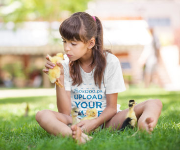 T-Shirt Mockup Featuring a Girl Playing with Ducklings