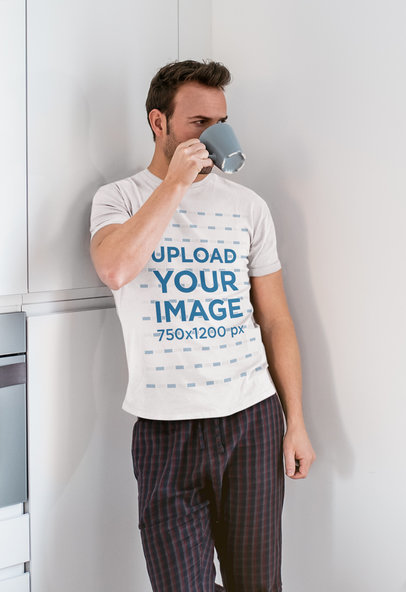 T-Shirt Mockup of a Man Drinking Coffee in His Kitchen