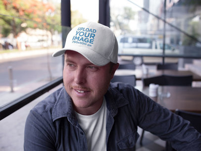 Dad Hat Mockup Being Worn by a Happy White Guy at a Restaurant