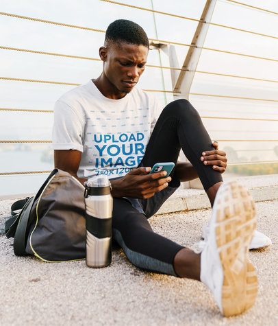 T-Shirt Mockup of a Fit Man Checking His Phone