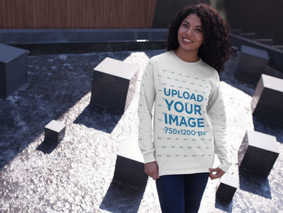 Smiling Woman Wearing a Long-Sleeve T-Shirt Mockup While at an Urban Structure