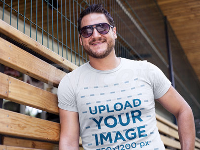 Cool Guy Wearing Sunglasses and a Tshirt Template While Lying Against a Storefront