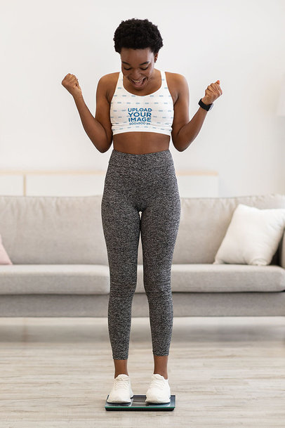 Sports Bra Mockup of a Happy Woman Standing on a Scale