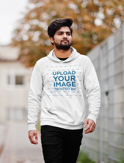 Mockup of a Bearded Man Walking Down the Street While Wearing a Hoodie