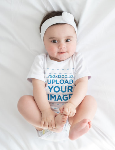 Onesie Mockup Featuring a Baby Girl Lying on a White Bed m6223-r-el2