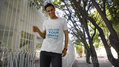 T-Shirt Video of a Young Man Posing by a Fence 