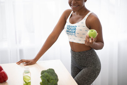 Sports Bra Mockup of a Happy Woman Holding an Apple