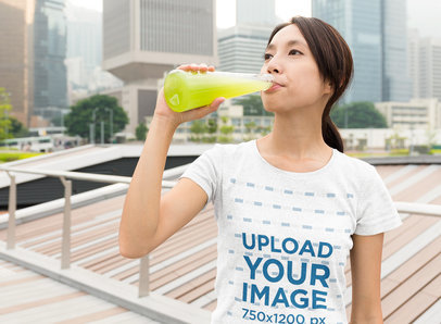 Heather T-Shirt Mockup of a Woman Drinking Juice in the City