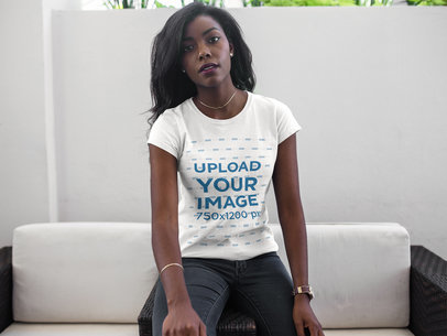 T-Shirt Mockup Being Worn by a Young Woman Sitting Down 