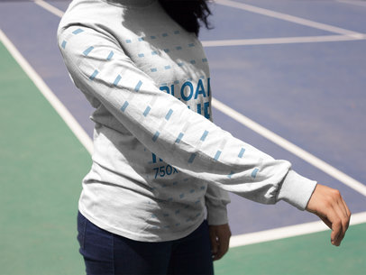 Woman Showing Her Right Arm While Wearing a Long Sleeve Tshirt Mockup at a Tennis Court