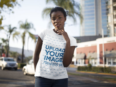 Mockup of a Woman Wearing a Round Neck T-shirt While Posing in the City 