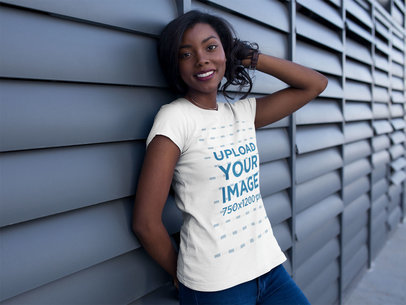 T-Shirt Mockup Featuring a Smiling Woman Leaning Against a Wall