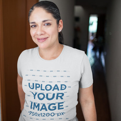 T-Shirt Mockup Being Worn by a Middle Aged Hispanic Woman Smiling While in a Hallway