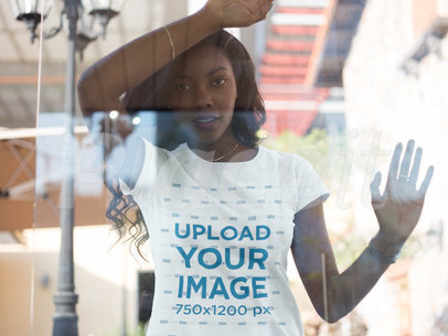 Through the Window Mockup of a Young Woman Wearing a T-shirt While Lying on the Window 16053