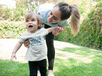 Mockup of a Smiling Baby Girl Wearing a T-shirt with Her Mom
