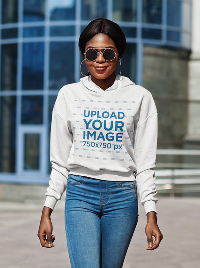 Hoodie Mockup of a Smiling Woman With Sunglasses Posing in the Street