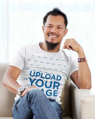 T-Shirt Mockup Featuring a Bearded Man Sitting on a Sofa