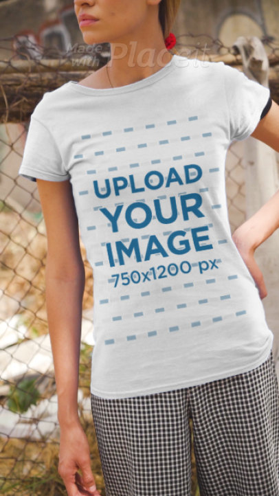 T-Shirt Video Maker Featuring a Serious Woman Posing Against a Fence  3388v