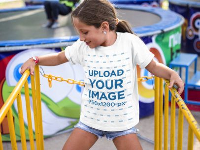 Little Girl Wearing a Round Neck Tee Mockup While at a Yellow Railing
