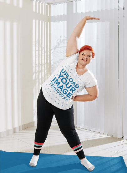T-Shirt Mockup of a Woman with Red Hair Stretching at Home 