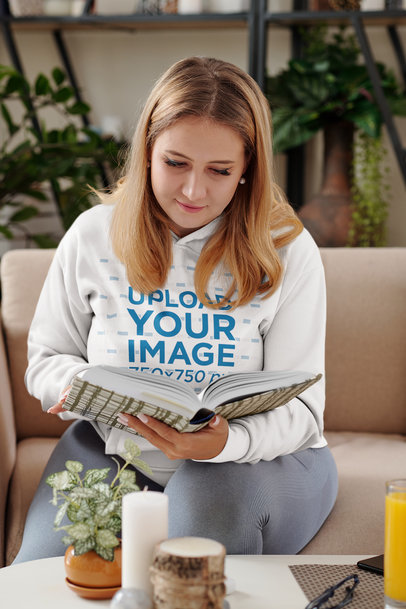 Hoodie Mockup of a Woman Reading a Book at Home