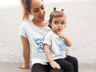 Mockup of a Mother with Her Baby Girl Wearing T-Shirts While Sitting