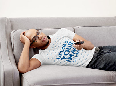 T-Shirt Mockup of a Man Watching TV From His Couch