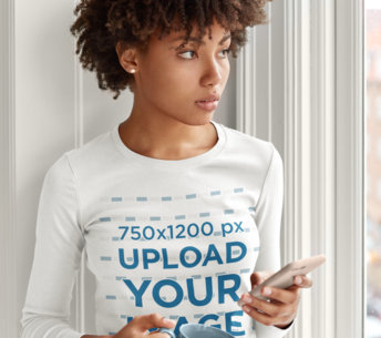 Long Sleeve Tee Mockup of a Woman with Afro Hair Holding Her Smartphone