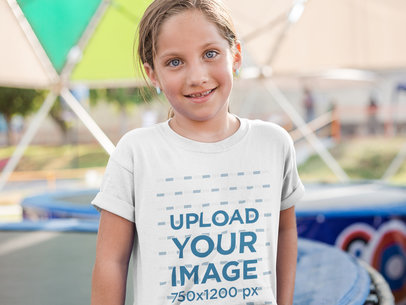 Smiling Little Girl Wearing a T-Shirt Mockup While Outdoors