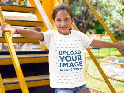 Smiling Kid Going Down Some Yellow Stairs While Wearing a Round Neck T-Shirt Mockup
