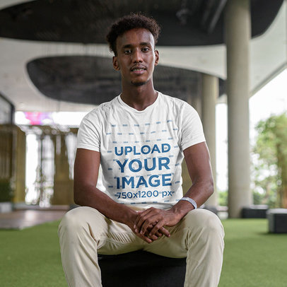 T-Shirt Mockup of a Happy Man Sitting in an Urban Area m7675 r-el2