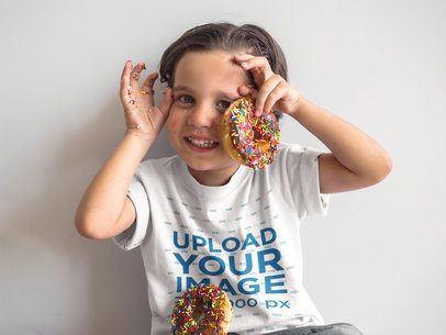 Mockup of a Happy Kid Playing with Donuts While Wearing a Round Neck T-Shirt