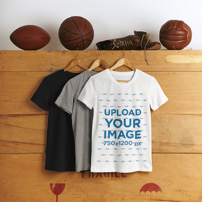 Mockup of Three Rounded-Neck T-Shirts Hanging on a Wooden Box