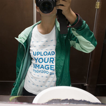 Mockup of a Woman Taking a Selfie with a Camera in a Bathroom While Wearing a T-Shirt Mockup
