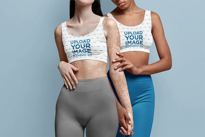 Mockup of Two Women Wearing Sublimated Sports Bra at a Studio