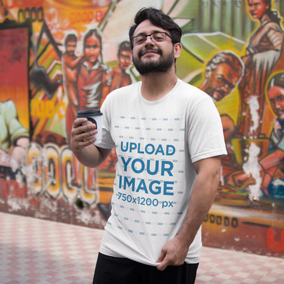 Happy Customer Showing his T-Shirt Mockup While in an Urban Area a16218