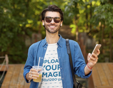 T-Shirt Mockup of a Happy Young Man Holding an Iced Tea 