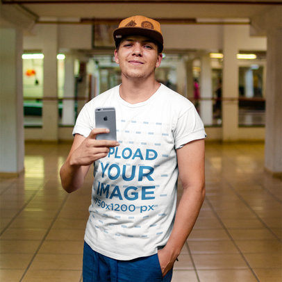 Selfie Mockup of a Young Guy Wearing a T-Shirt and a Hat While Facing a Mirror