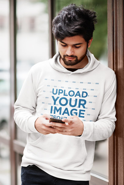 Hoodie Mockup of a Bearded Man Checking His Phone