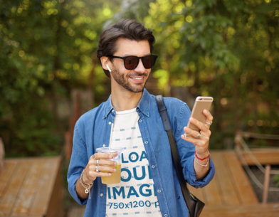 Basic T-Shirt Mockup Featuring a Man Reading a Text Message While Walking at a Park 