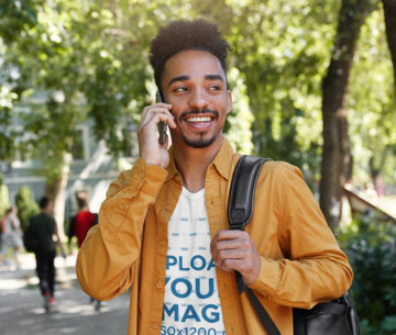 T-Shirt Mockup of a Young Man on The Phone While on His Way to School