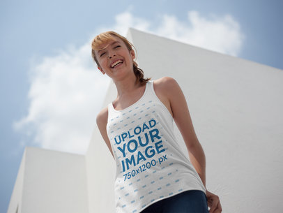Smiling White Woman Wearing a Bella Canvas Tank Top Mockup While Outdoors