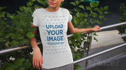 T-Shirt Video Featuring a Happy Woman Posing by an Urban Railing